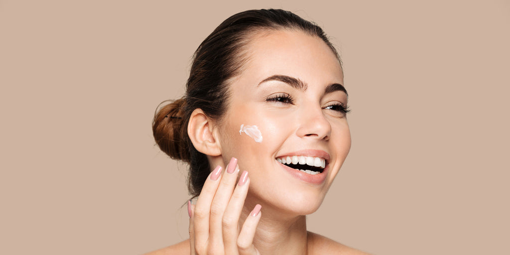 woman applying skincare to face.